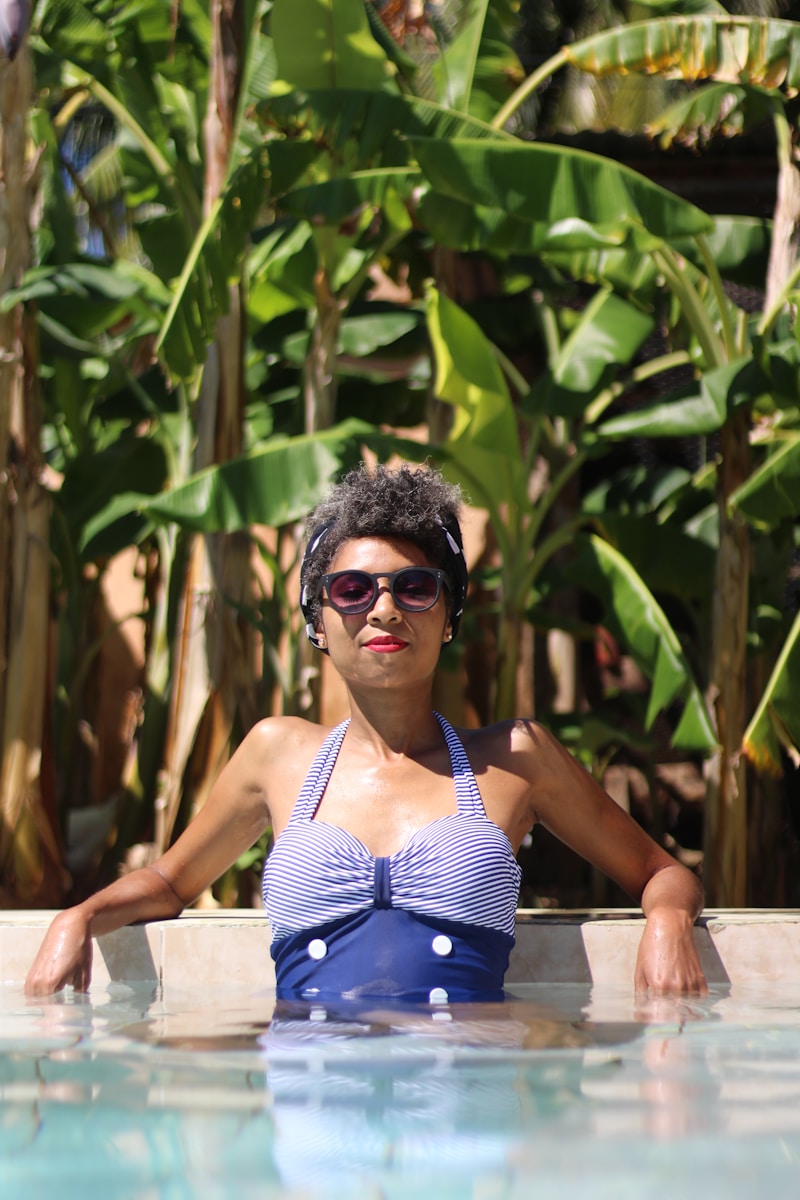 woman leaning on concrete near banana trees