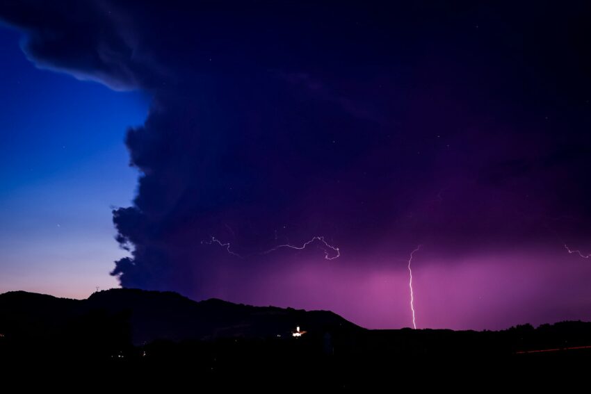 a purple sky with a lightning bolt in the distance