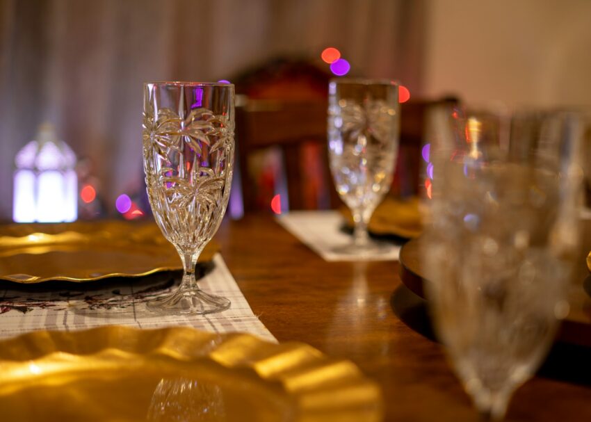 a wooden table topped with glasses and plates