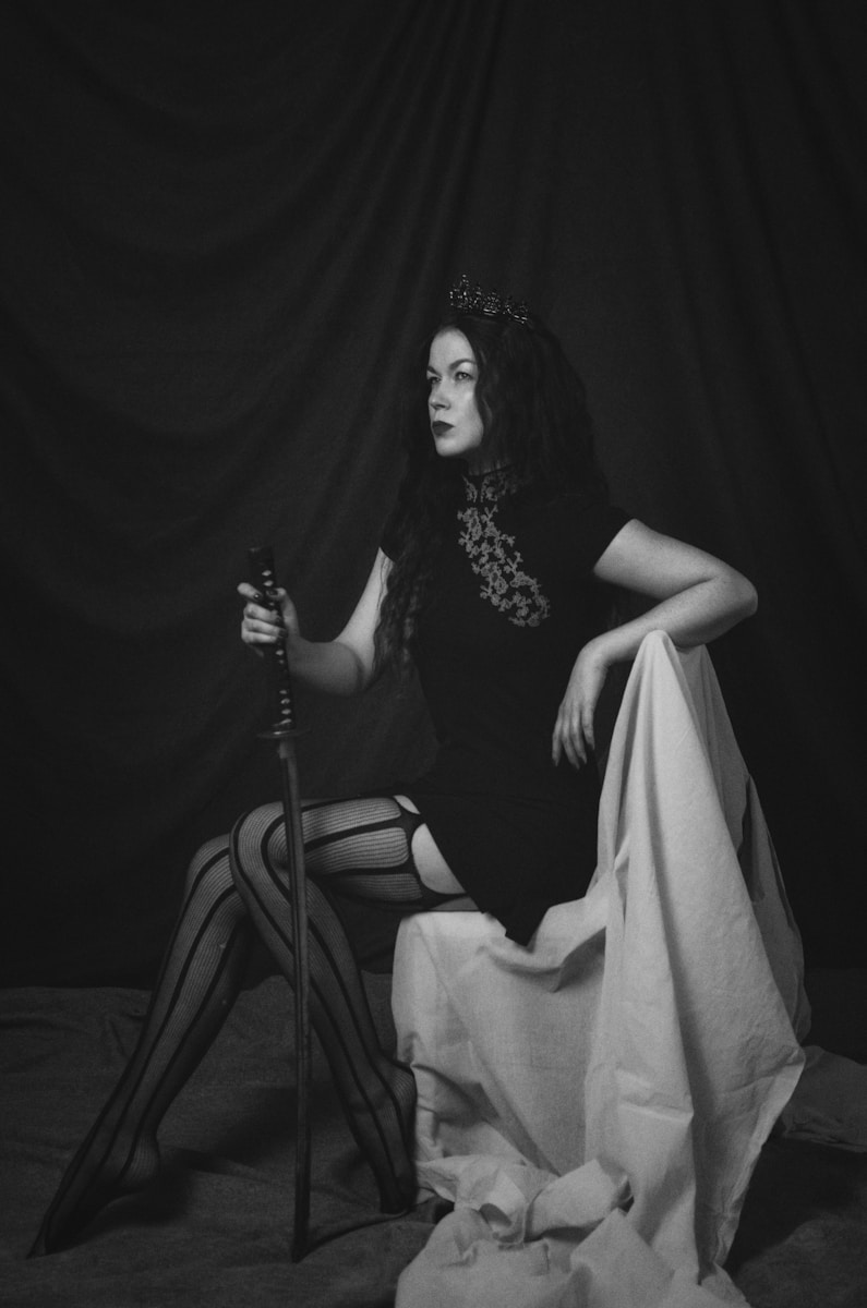 a woman sitting on top of a chair in a black and white photo